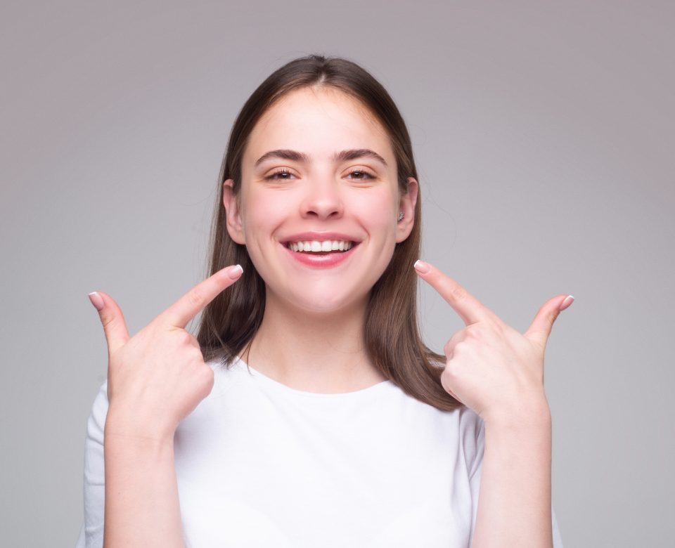 Beautiful Woman Pointing To Teeth. Beautiful Smile With White Teeth. Closeup Smiling Woman Mouth. Dental Health.
